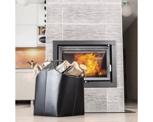 Un coș negru de lemne umplut cu lemne în fața unui șemineu.