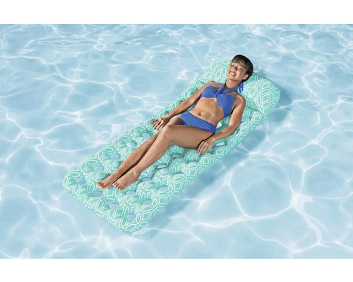 Femeie relaxându-se pe o saltea pneumatică în piscină