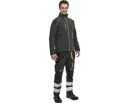 Bărbat purtând haine de lucru constând dintr-o jachetă, pantaloni și pantofi de siguranță