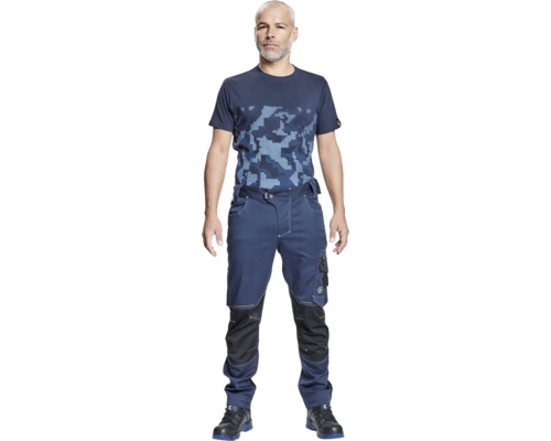 Bărbat purtând îmbrăcăminte de lucru constând dintr-un tricou, pantaloni de lucru și pantofi de siguranță.