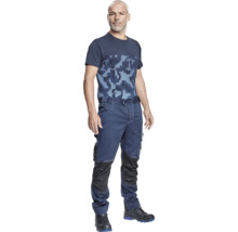 Bărbat poartă haine de lucru constând dintr-un tricou și pantaloni de lucru.