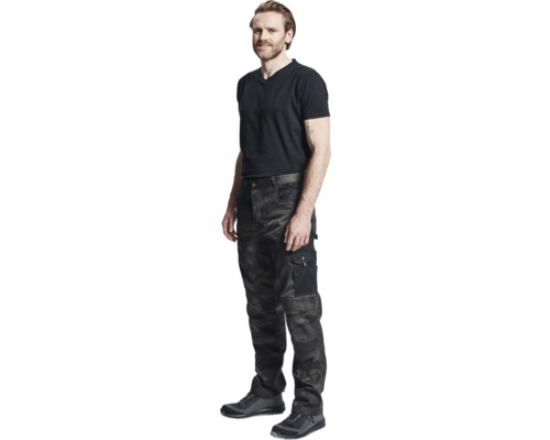 Bărbat în pantaloni de lucru camuflaj, tricou și pantofi de siguranță