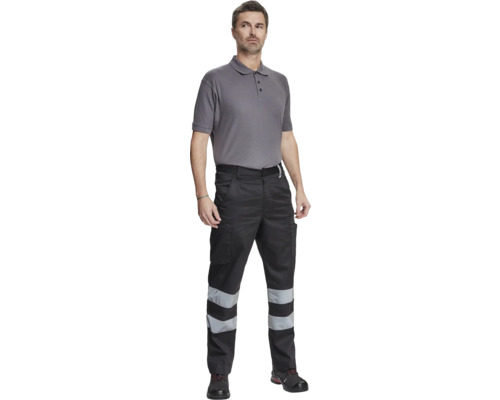 Bărbat purtând pantaloni de lucru cu benzi reflectorizante și tricou polo uni