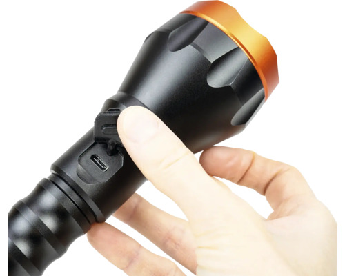 Mâna deschide capacul portului USB al unei lanterne.