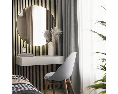 Interior modern cu o oglindă rotundă deasupra unui birou alb și un scaun