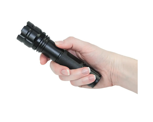 O mână ține o lanternă neagră.