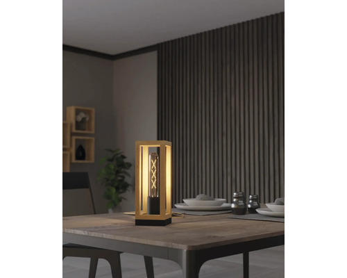 Lampă de masă decorativă din lemn și metal pe o masă de sufragerie.