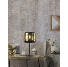 Scenă decorativă cu lampă de masă, ceramică și textile pe o măsuță laterală.