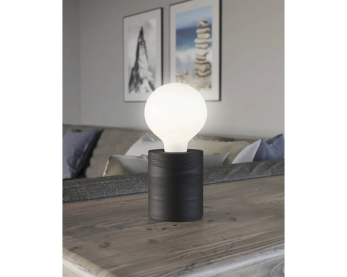 Lampă de masă decorativă cu abajur rotund luminos și bază din lemn închis la culoare pe o masă