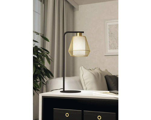 Lampă decorativă de masă cu bază metalică și abajur pe o noptieră.