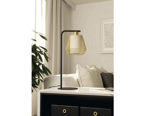 Lampă decorativă de masă cu abajur din plasă metalică pe o masă