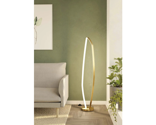 Lampă de podea modernă în sufragerie lângă o canapea și o plantă de interior
