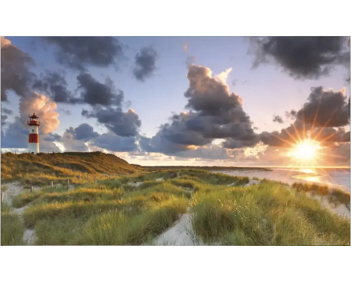 Peisaj cu far în iarba dunelor sub cer înnorat