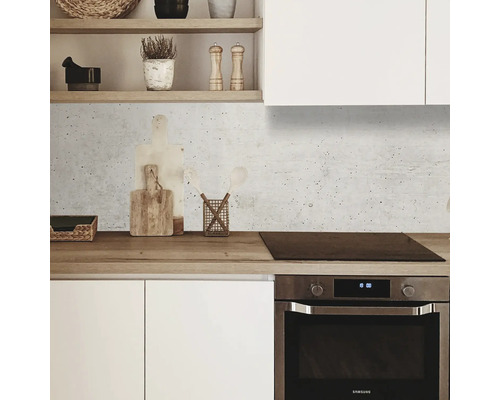 Scenă de bucătărie cu dulapuri albe, blat de lucru din lemn și fundal din beton