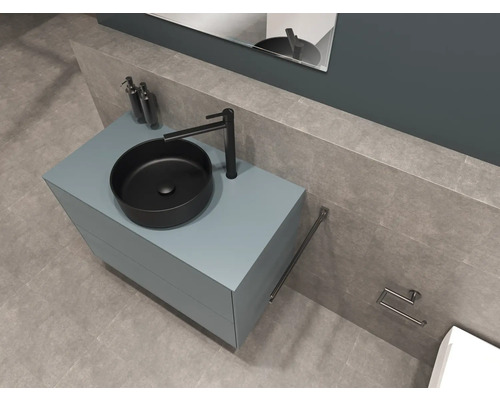 Baie modernă cu lavoar așezat pe blat, dulap de lavoar, baterie, suport pentru prosop și suport pentru hârtie igienică.