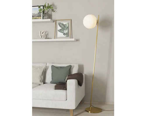 Sufragerie cu canapea, rafturi și lampadar cu abajur sferic.