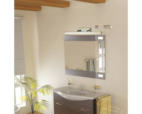 Baie cu chiuvetă, oglindă și iluminare pentru o atmosferă luminoasă și organizată.