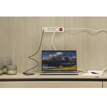 Laptop, smartphone și prelungitor pe un birou.