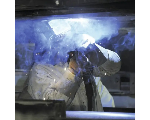 Sudor la lucru cu echipament de sudură și cască de sudură.