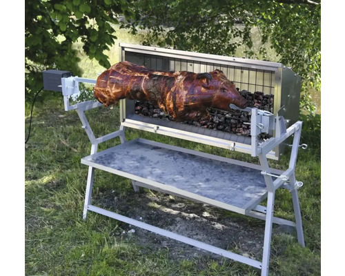 Porc la grătar pe un grătar rotativ în aer liber.