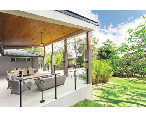 Terasa acoperită cu mobilier de ședere, masă de sufragerie și vedere la grădină