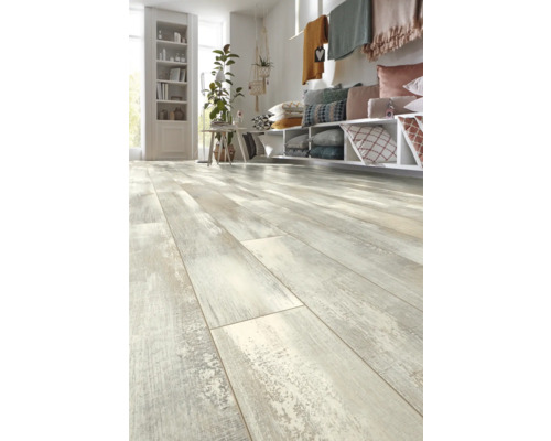 Cameră de zi luminoasă cu podea laminată cu aspect de lemn, rafturi, perne și decorațiuni