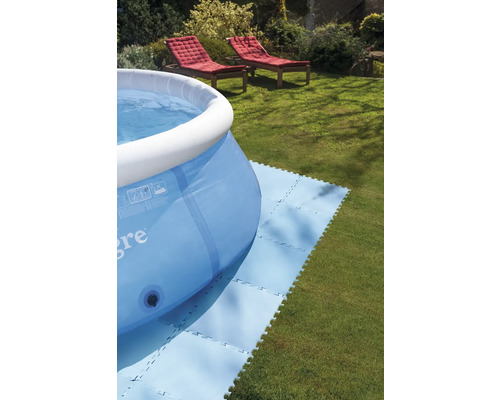 Piscină gonflabilă pe gazon cu plăci de bază pentru piscină și două șezlonguri în fundal.