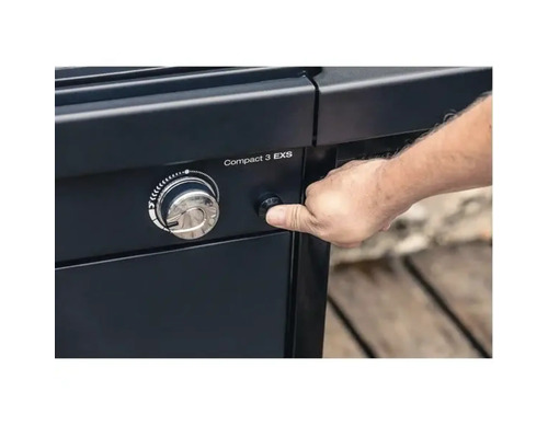 Persoană care apasă butonul de aprindere al unui grătar pe gaz