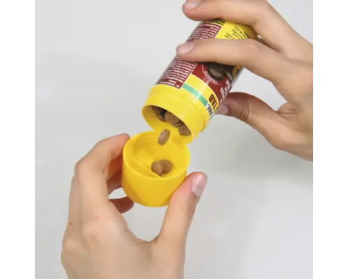 Alimente sub formă de tablete sunt scoase dintr-o cutie galbenă