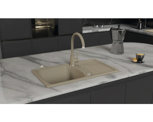 Chiuvetă de bucătărie bej cu uscător și baterie pe o insulă de bucătărie