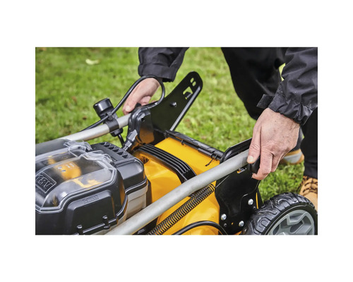 Scenă de grădină cu o mașină de tuns iarba pregătită pentru utilizare.