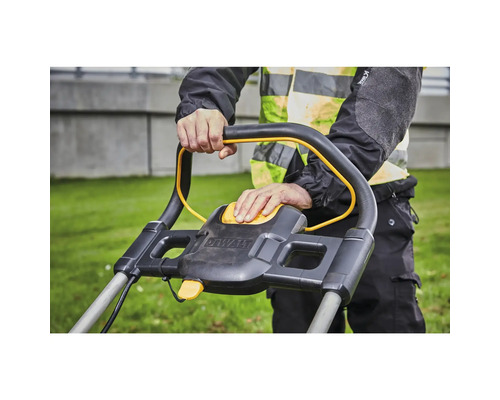 Prim-plan cu o persoană care operează o mașină de tuns iarba marca Dewalt.