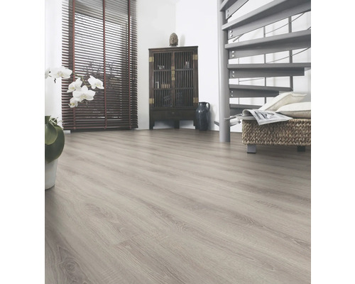 Pardoseală laminată deschisă la culoare într-un living cu mobilier și o scară spiralată.