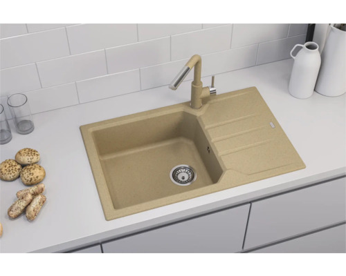 Chiuvetă bej cu picurător și baterie asortată pe un blat de bucătărie