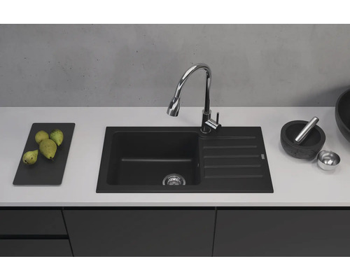 Chiuvetă neagră cu zonă de scurgere și baterie pe un blat de bucătărie