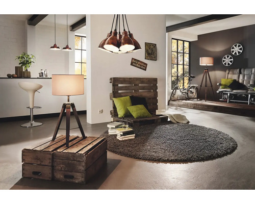 Interior luminos cu zonă de relaxare din paleți, lampadar și covor rotund