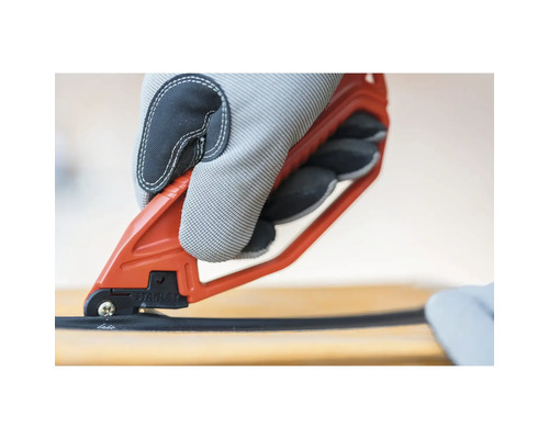 O mână cu mănușă de lucru taie un cablu cu un clește de cablu.