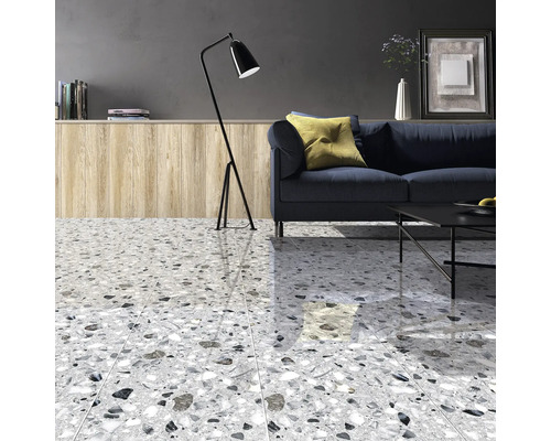 Cameră de zi cu podea de terrazzo, canapea, lampadar și măsuță de cafea.