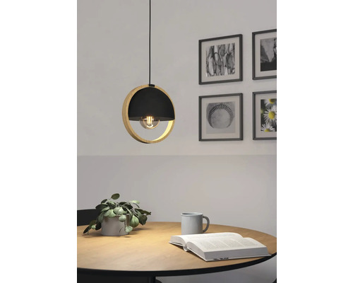 Lampa suspendată din lemn și metal deasupra unei mese cu decorațiuni