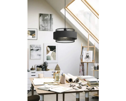 Lampă suspendată modernă din metal și material textil deasupra unei mese într-un atelier.