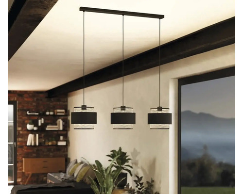 O lustră suspendată cu trei becuri din metal cu abajur textil atârnă în cameră.