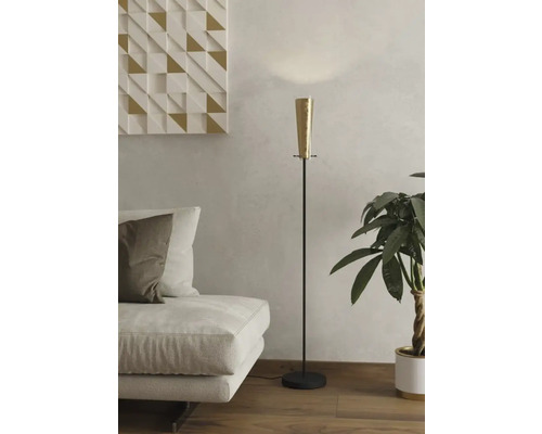 Fotografie de interior a unui living cu lampadar, canapea și plantă de interior