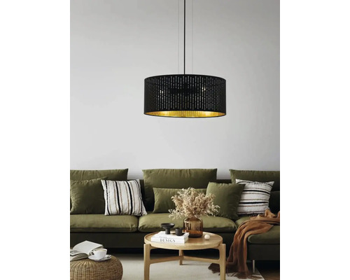 Lampa suspendată neagră cu interior auriu deasupra unei scene de sufragerie.