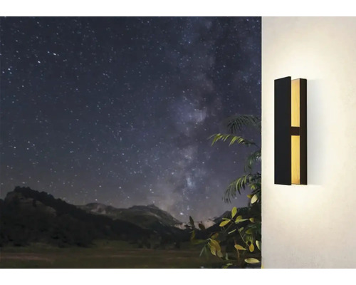 Lumină de perete modernă din metal pe un perete cu un peisaj montan în fundal