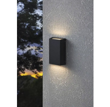 Lampa neagră de perete pentru exterior iluminează un perete