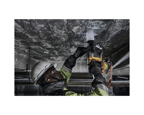 Un muncitor în construcții fixează ceva de un tavan cu un pistol de împușcat bolțuri.