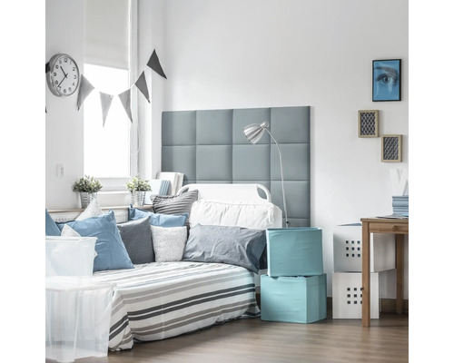 Cameră luminoasă cu pat, perne, cutii de depozitare și decorațiuni pentru un ambient ordonat.