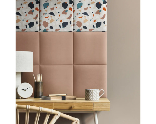 Design decorativ de perete cu panouri tapițate și model terrazzo deasupra unui birou.