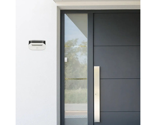 Cutie poștală pe un perete de casă lângă o ușă de intrare