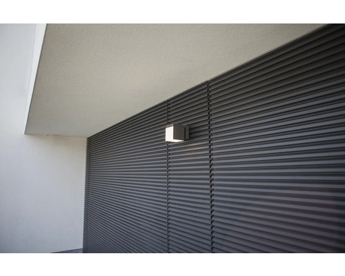 Lumină de perete pătrată pe o fațadă cu structură liniară orizontală.